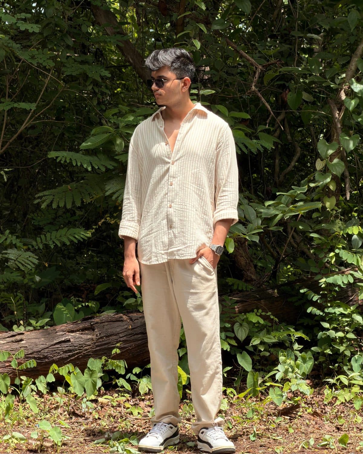 Omkar Choudhari standing in front of dense green foliage.
